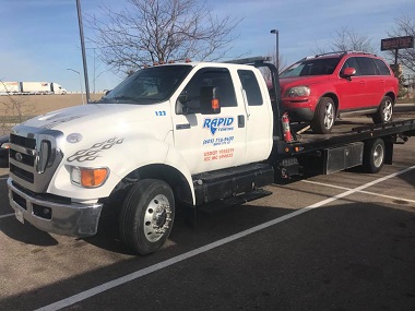 Red SUV on flatbed tow truck in Rapid City, SD